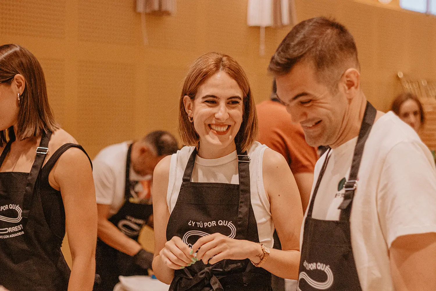 Participantes del Teambuilding Saludable de Aquadeus ríen mientras cocinan